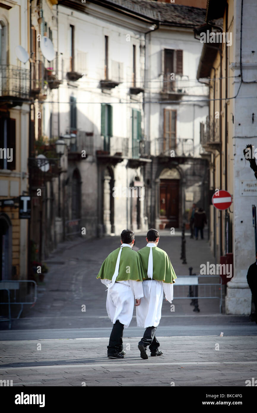 In quasi una scena senza tempo due giovani nel cerimoniale di Domenica di Pasqua costume attraversare la Piazza Garibaldi a Sulmona, Abruzzo, Italia Foto Stock