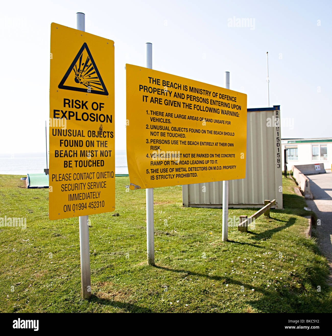 Cartelli di avvertimento per gli esplosivi trovati sulla spiaggia a Pendine sands con il rivelatore di metalli uso vietato Wales UK Foto Stock