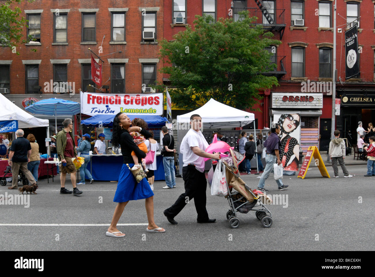 Coppia giovane con bambino tra le altre persone che passeggiano Nona Avenue a New York della nona Nona Avenue International Food festival Foto Stock