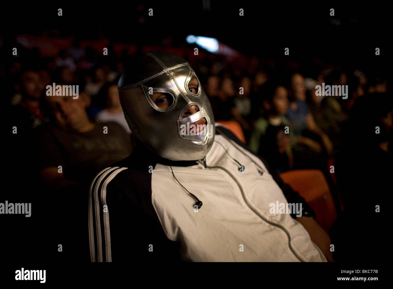 Una ventola cheers indossando un Lucha Libre orologi maschera un wrestling lotta in Arena Messico, Città del Messico Foto Stock