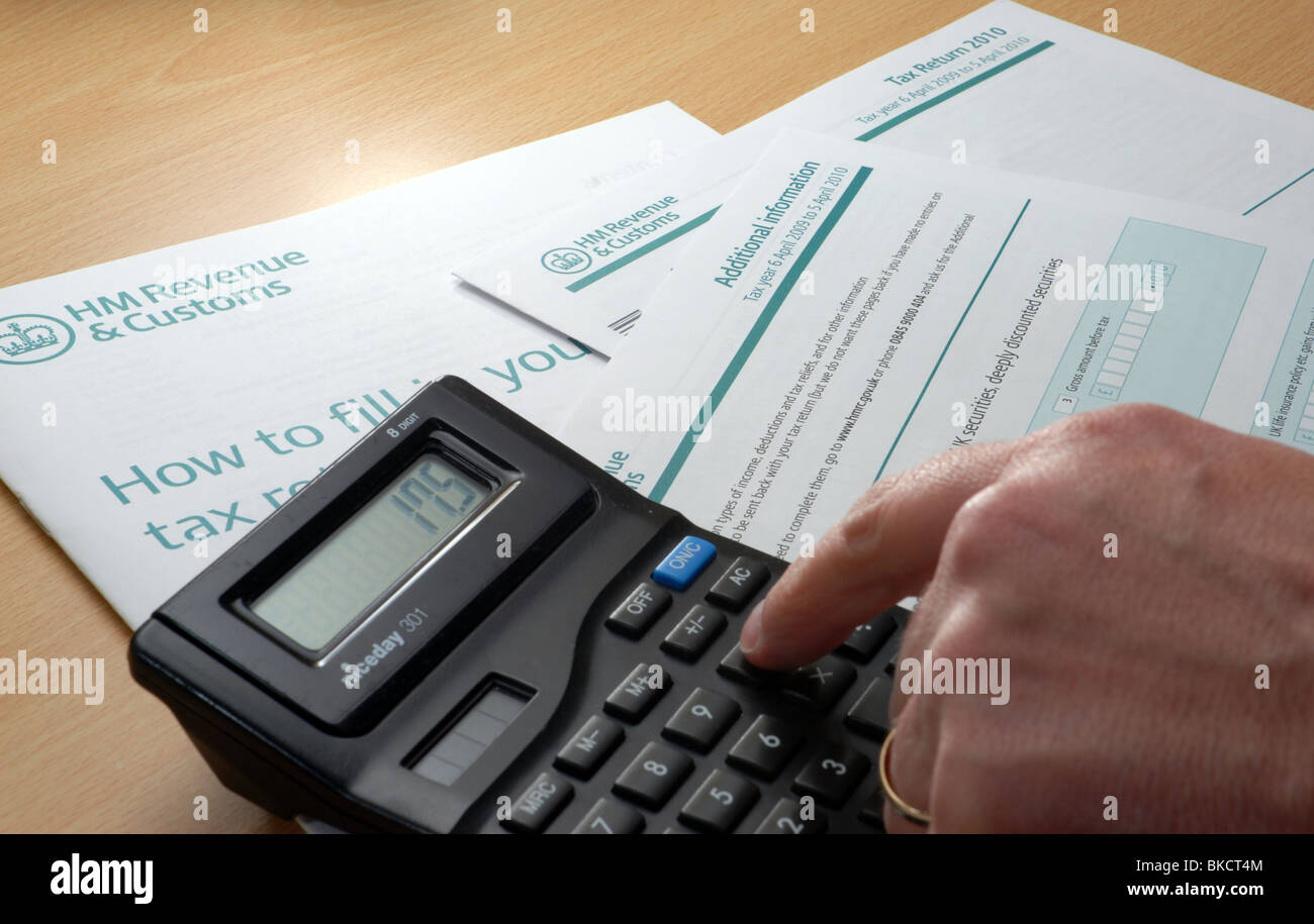 Avviare il doloroso processo di completamento di un ritorno fiscale. Pronti con penna e calcolatrice per compilare le informazioni aggiuntive Foto Stock