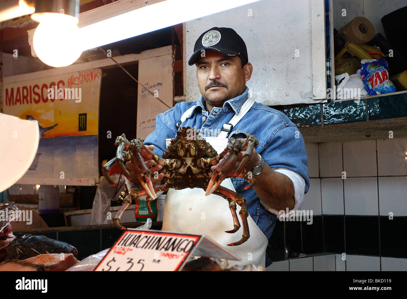 Pescatore al grande mercato del pesce di Ensenada mostrante un grande re granchi catturati che mattina.Il Messico Foto Stock