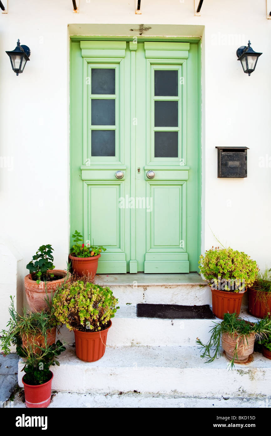 Verde porta greca con vasi di fiori sulla scala Foto Stock