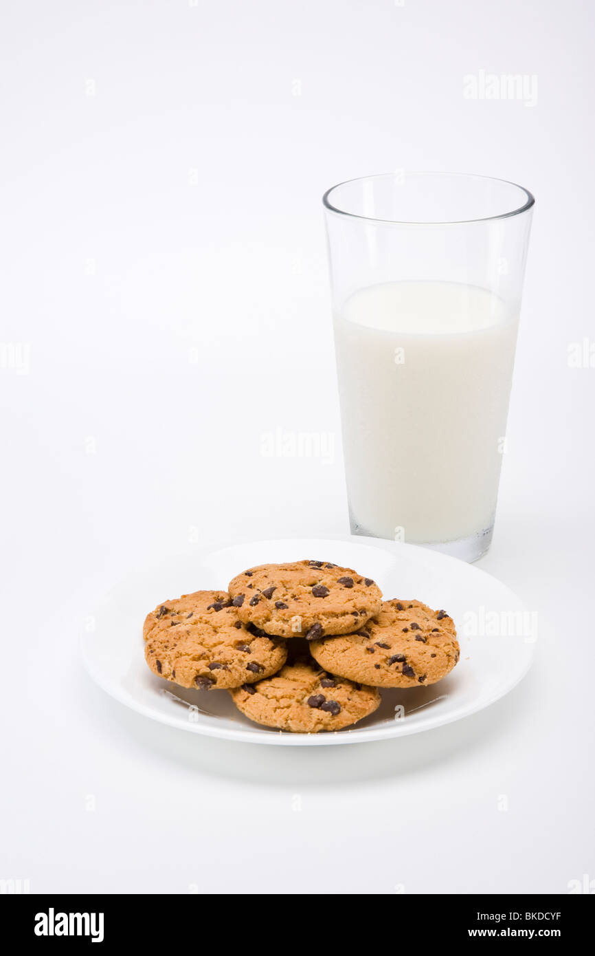 I biscotti al cioccolato con bicchiere di latte su sfondo bianco Foto Stock
