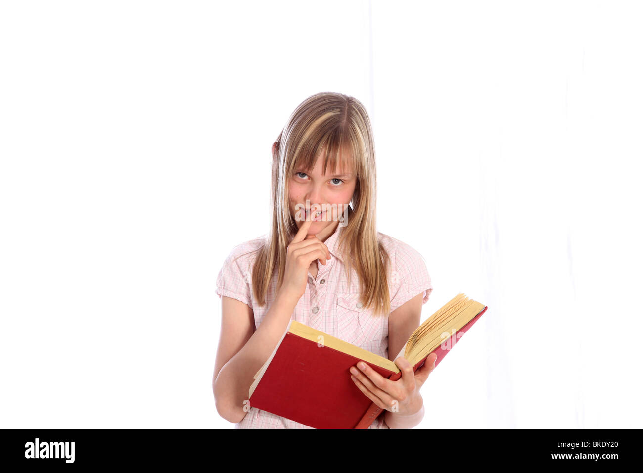 Felice ragazza giovane con un libro rosso. Essa guarda verso la telecamera e sorrisi - Tagliare Foto Stock