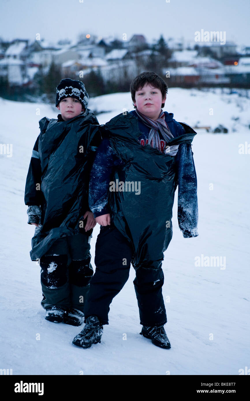 Due ragazzi in posa per la telecamera in caso di neve. Hafnarfjordur, una maggiore area di Reykjavik, Islanda Foto Stock