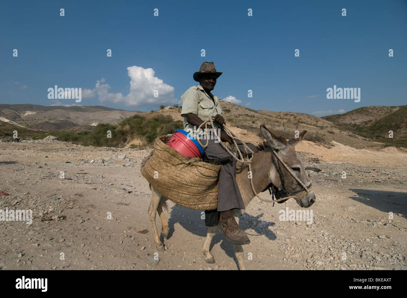 Un abitante locale cavalcando un asino in Haiti Foto Stock