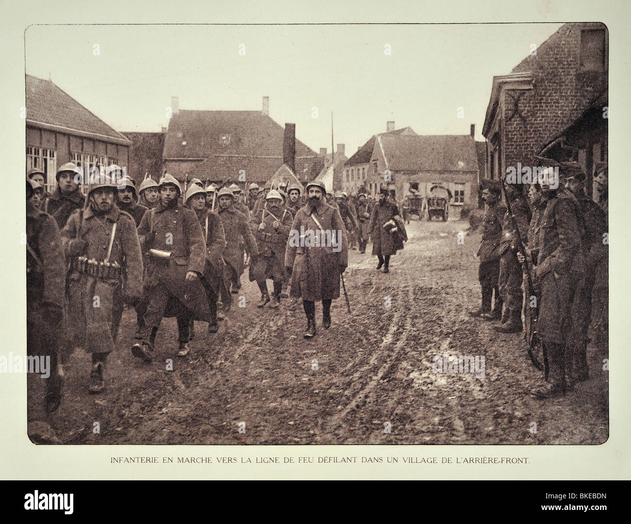 WW1 soldati di fanteria in marcia attraverso il villaggio e la voce per la parte anteriore in Fiandra occidentale durante la Prima Guerra Mondiale uno, Belgio Foto Stock