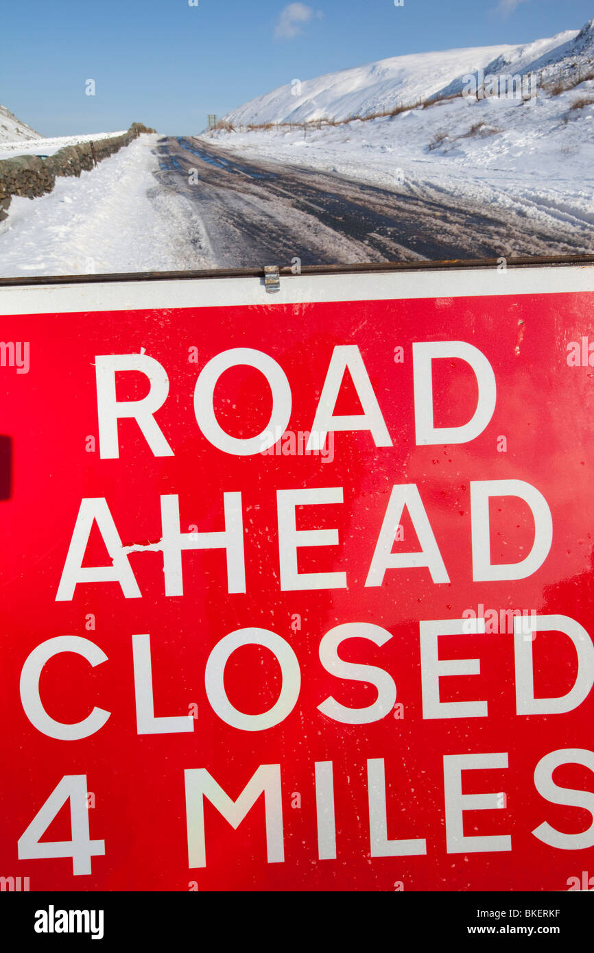 Una strada chiusa segno sulla sommità di Kirkstone Pass nel distretto del lago in inverno nevica Foto Stock