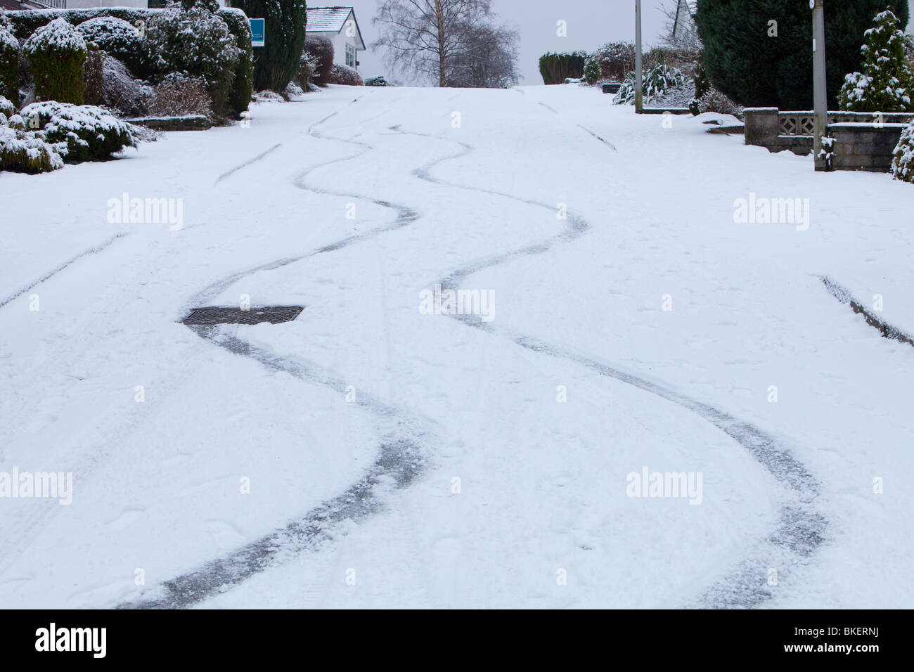 Segni di slittamento nella neve da un auto su una strada ripida in Ambleside Regno Unito Foto Stock