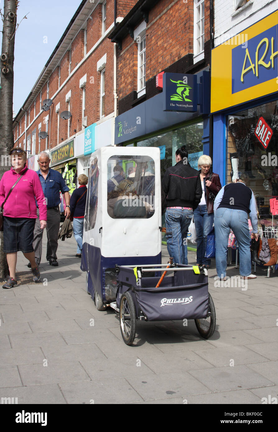 Una mobilità scooter su una strada trafficata in U.K. Foto Stock