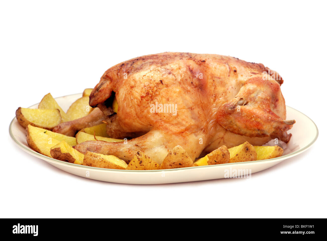 Pollo arrosto con patate su una piastra isolata Foto Stock