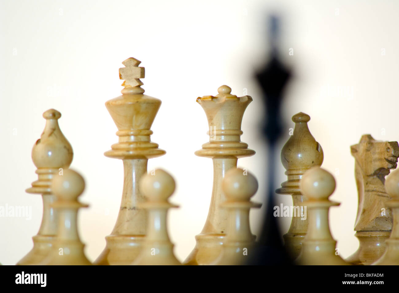 Scacchi, re nero nella parte anteriore del bianco pezzi di scacchi sulla scacchiera Foto Stock