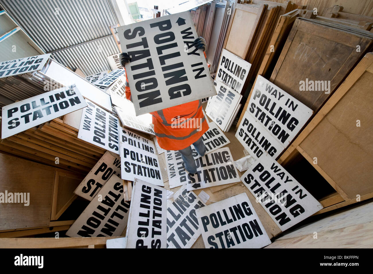 Un funzionario del Consiglio ordina attraverso centinaia di segni di polling e cabine nella corsa alle elezioni generali, REGNO UNITO Foto Stock