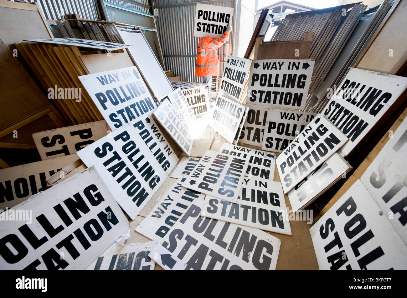 Un funzionario del Consiglio ordina attraverso centinaia di segni di polling e cabine nella corsa alle elezioni generali, REGNO UNITO Foto Stock