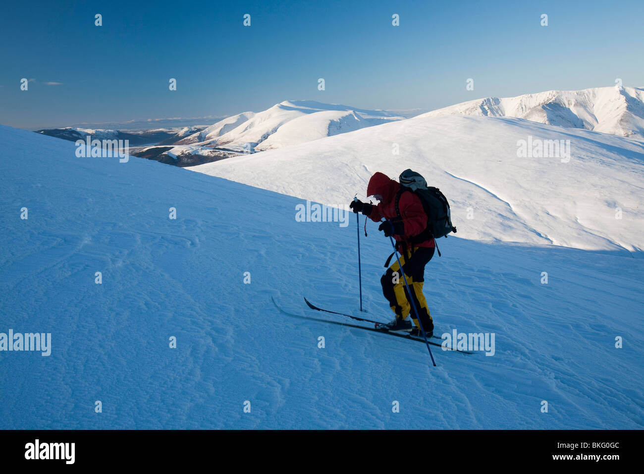 Mike garrese utilizzando sci di fondo sci di decend il picco di grande Dodd, a 2800 piedi, sulla estremità della gamma Helvellyn, REGNO UNITO Foto Stock