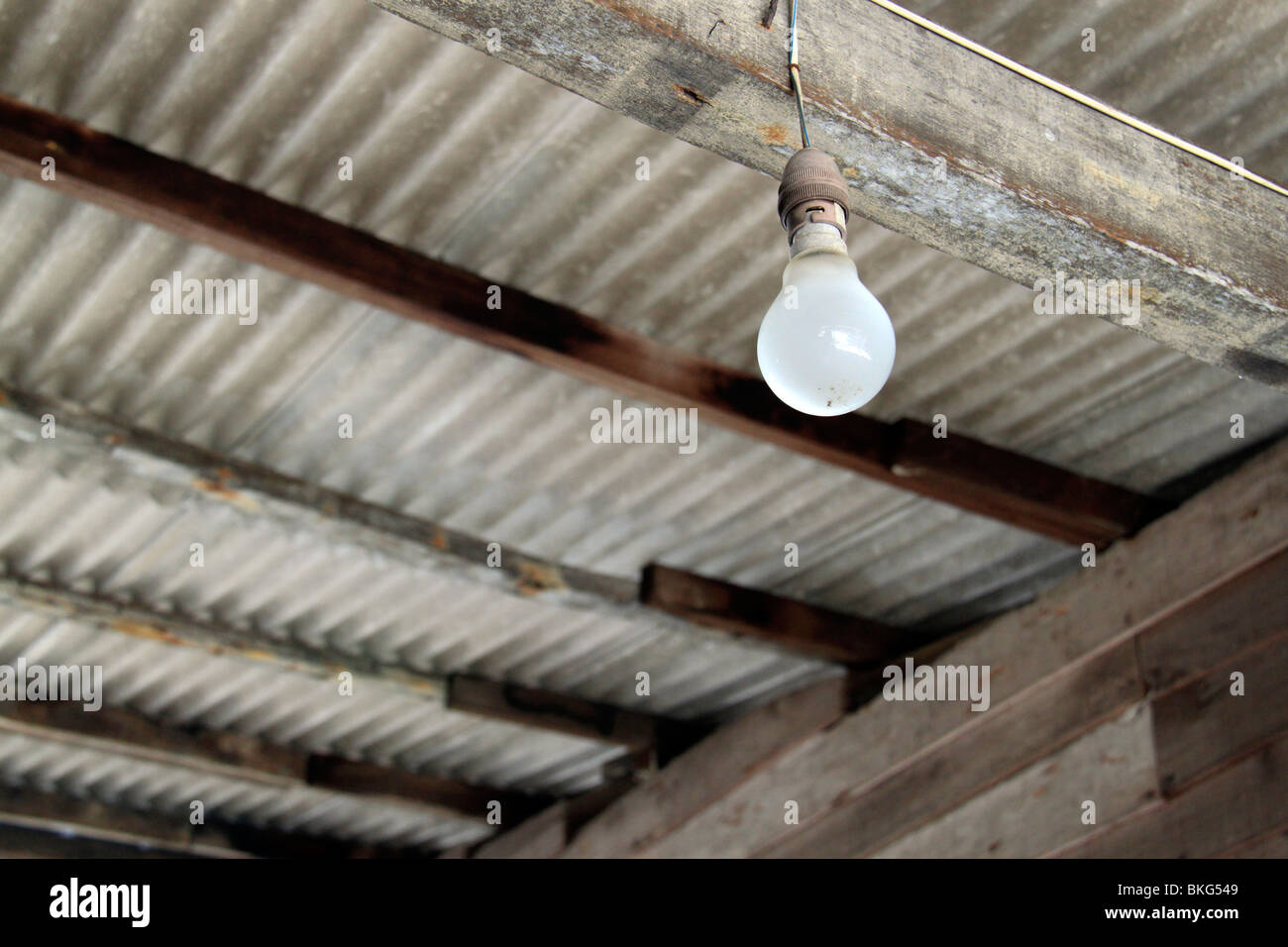 Una lampadina incandescente in un villaggio rurale casa. Foto Stock