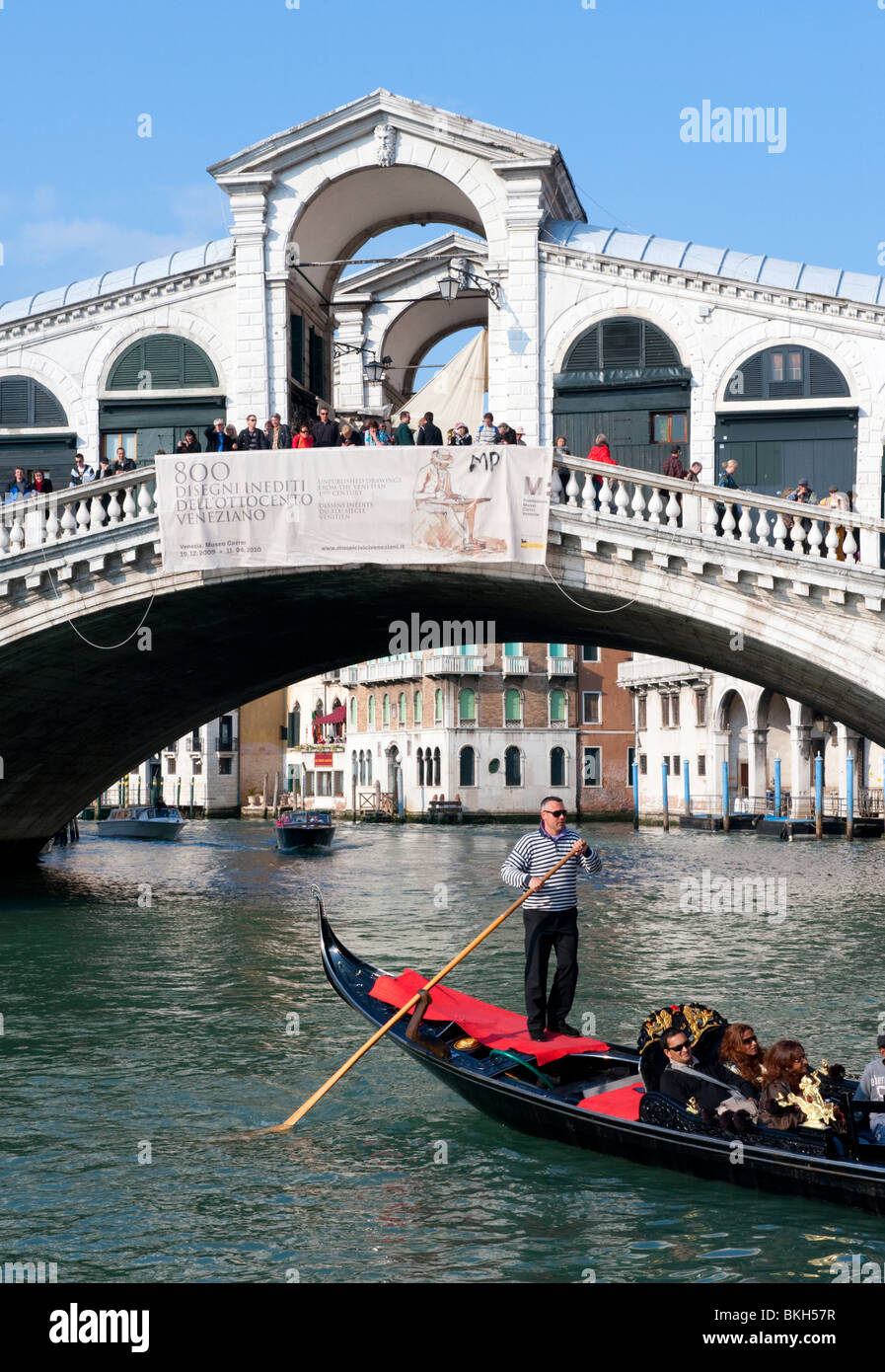 Gondoliere e la sua gondola sul Canal Grande al Ponte di Rialto a Venezia Italia Foto Stock