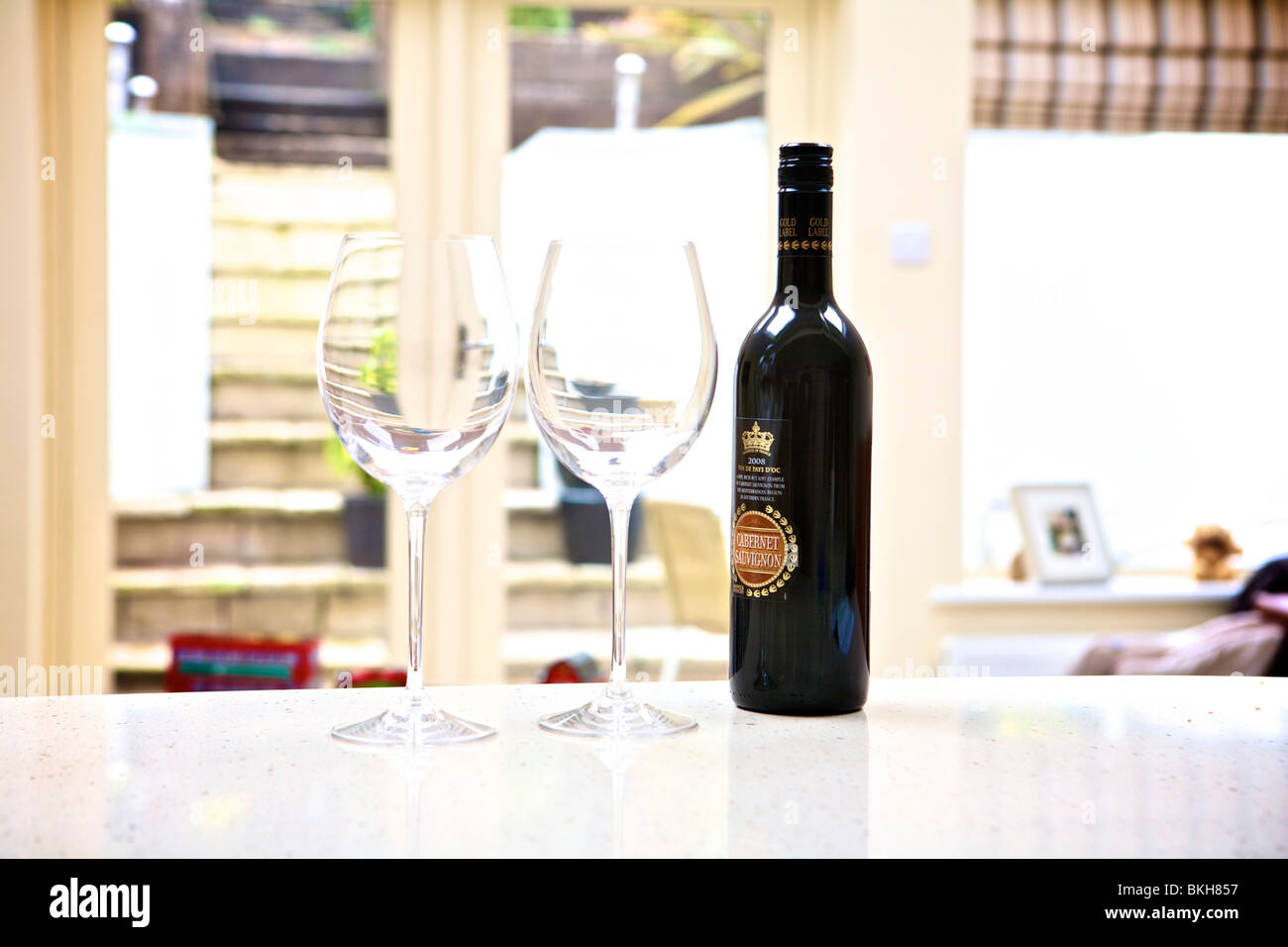 Due bicchieri e una bottiglia di vino in una cucina contemporanea impostazione Foto Stock