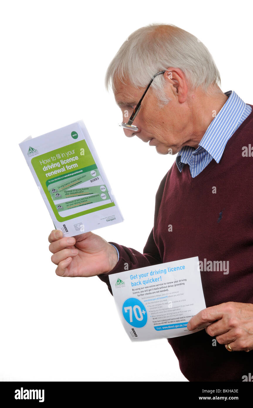 Ritratto di un uomo anziano la lettura di un DLVA opuscolo informazioni sul rinnovo della vostra patente di guida Foto Stock
