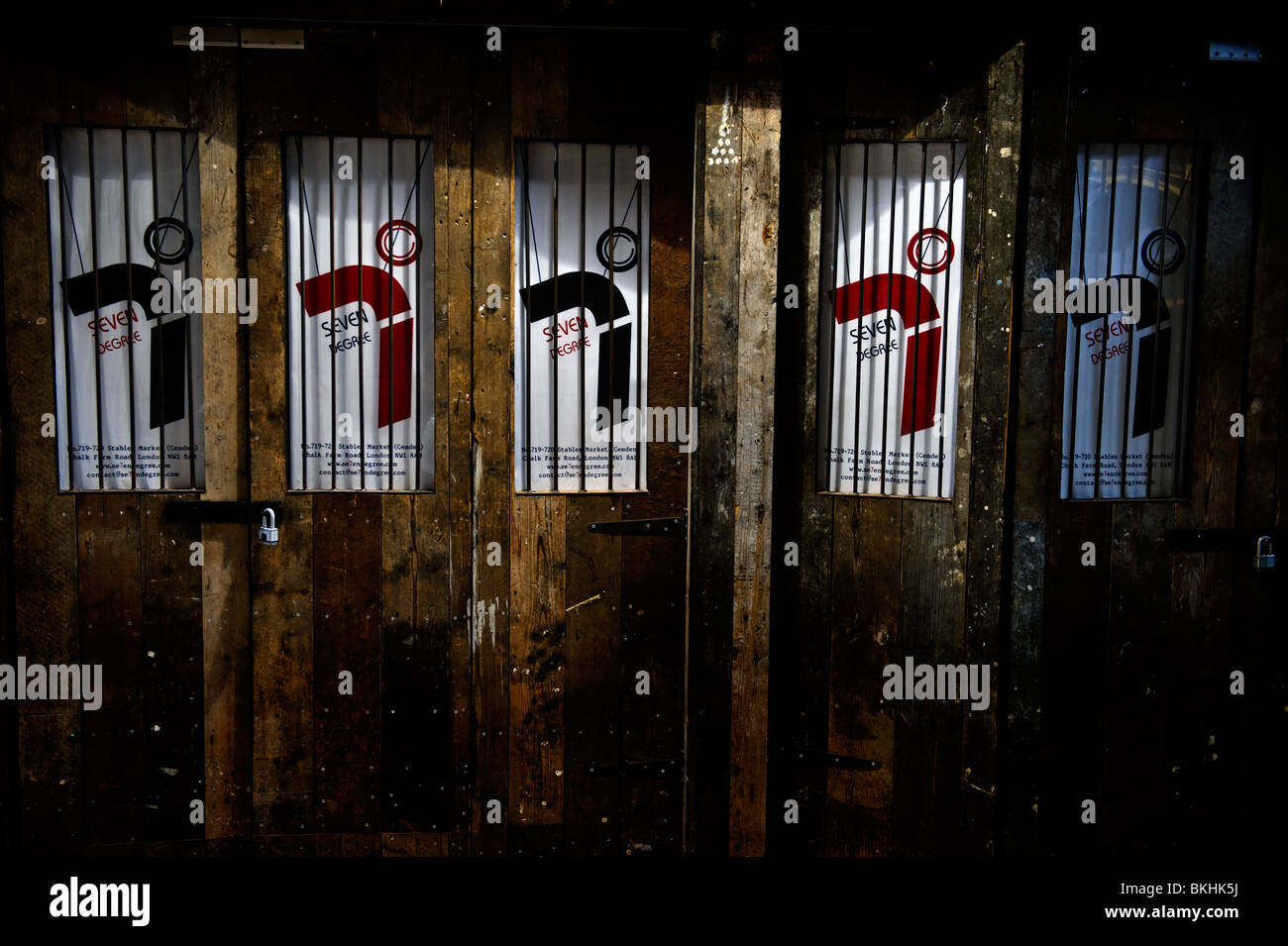 Bloccato in legno Porte stabile di fronte a negozi chiusi in stalle parte del mercato di Camden Market London REGNO UNITO Foto Stock