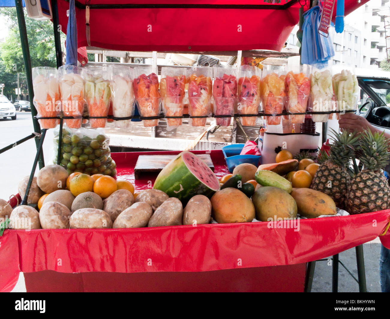 Confezionati colorati & tutta la frutta fresca visualizzato su una città del Messico i fornitori sul marciapiede carrello Foto Stock