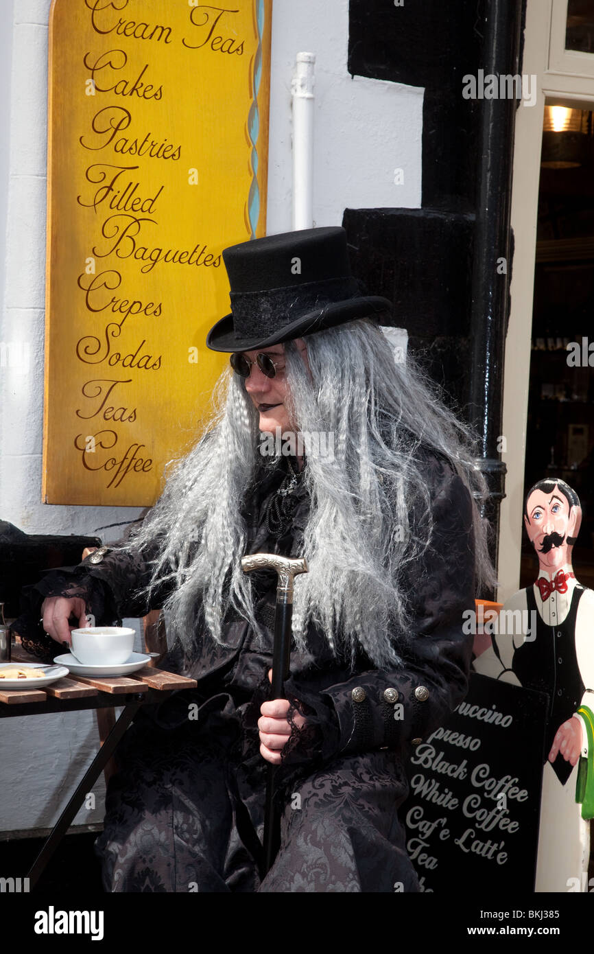 Prendendo tè, un uomo in costume seduto al di fuori di Whitby negozio di tè o caffè, al Festival di Goth, Aprile 2010 Foto Stock