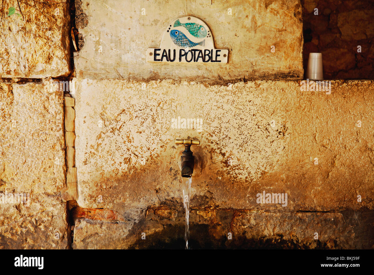 Gourdon, Provenza, Francia; il rubinetto dell'acqua con un cartello che diceva "eau Potable ' Foto Stock