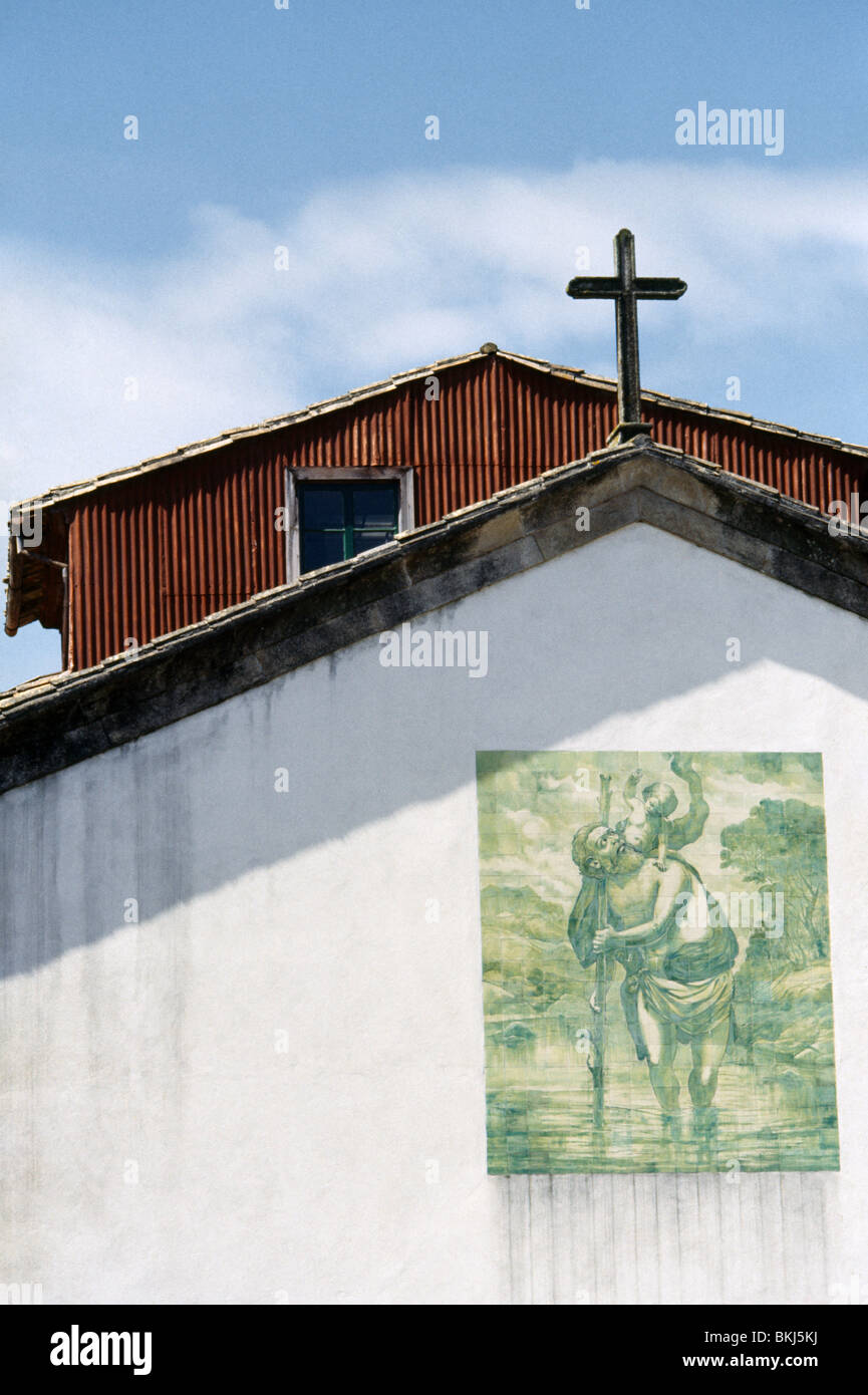 Barcelos Portogallo dipinto di San Cristoforo sulla parete della chiesa e una Croce Cristiana Foto Stock