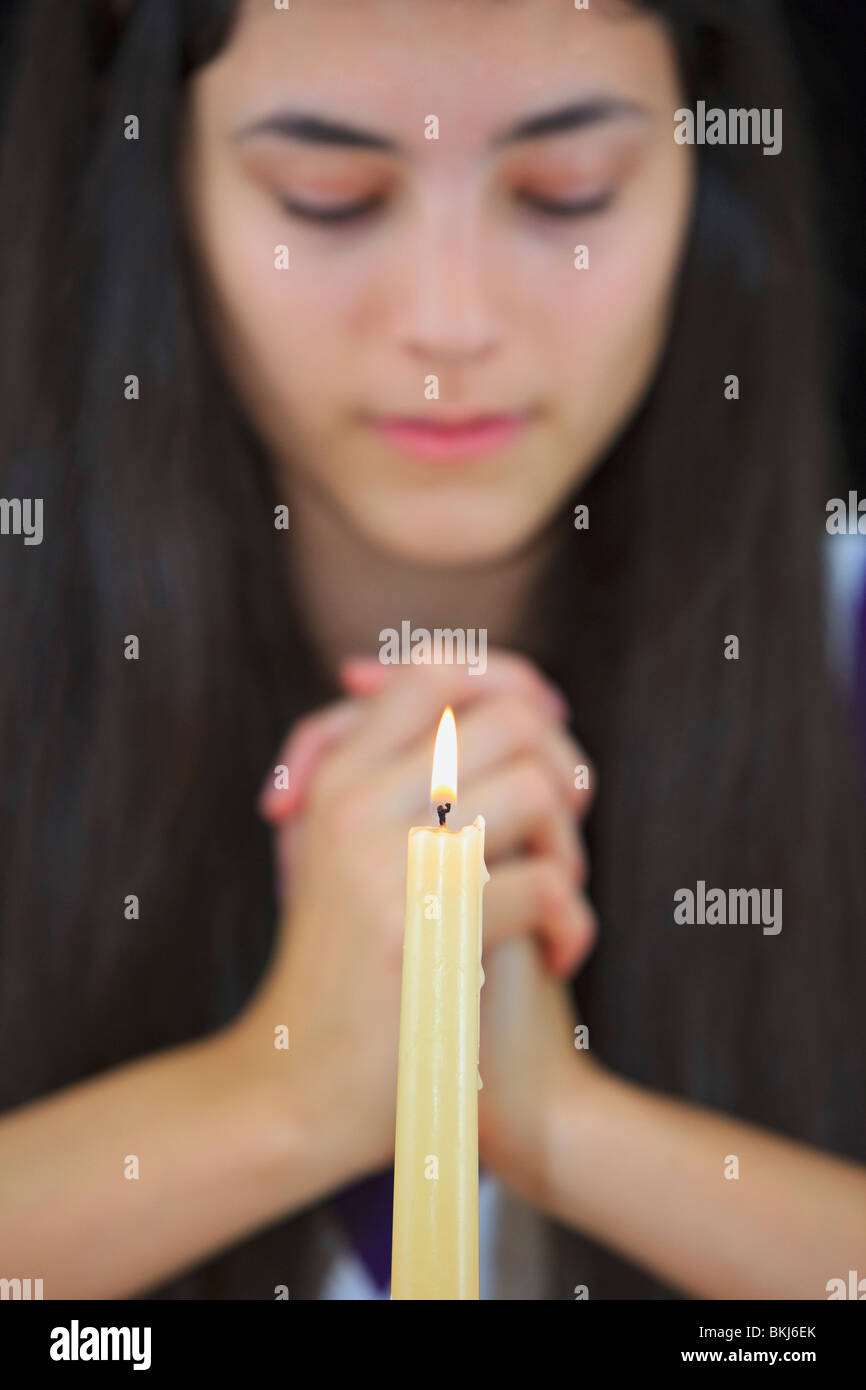 Una ragazza adolescente con mani giunte in preghiera Foto Stock