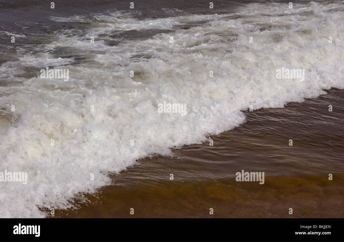 Mare mosso a Seaton Carew BEACH HARTLEPOOL con onde e schiuma a laminazione e schiantarsi sulla spiaggia Foto Stock