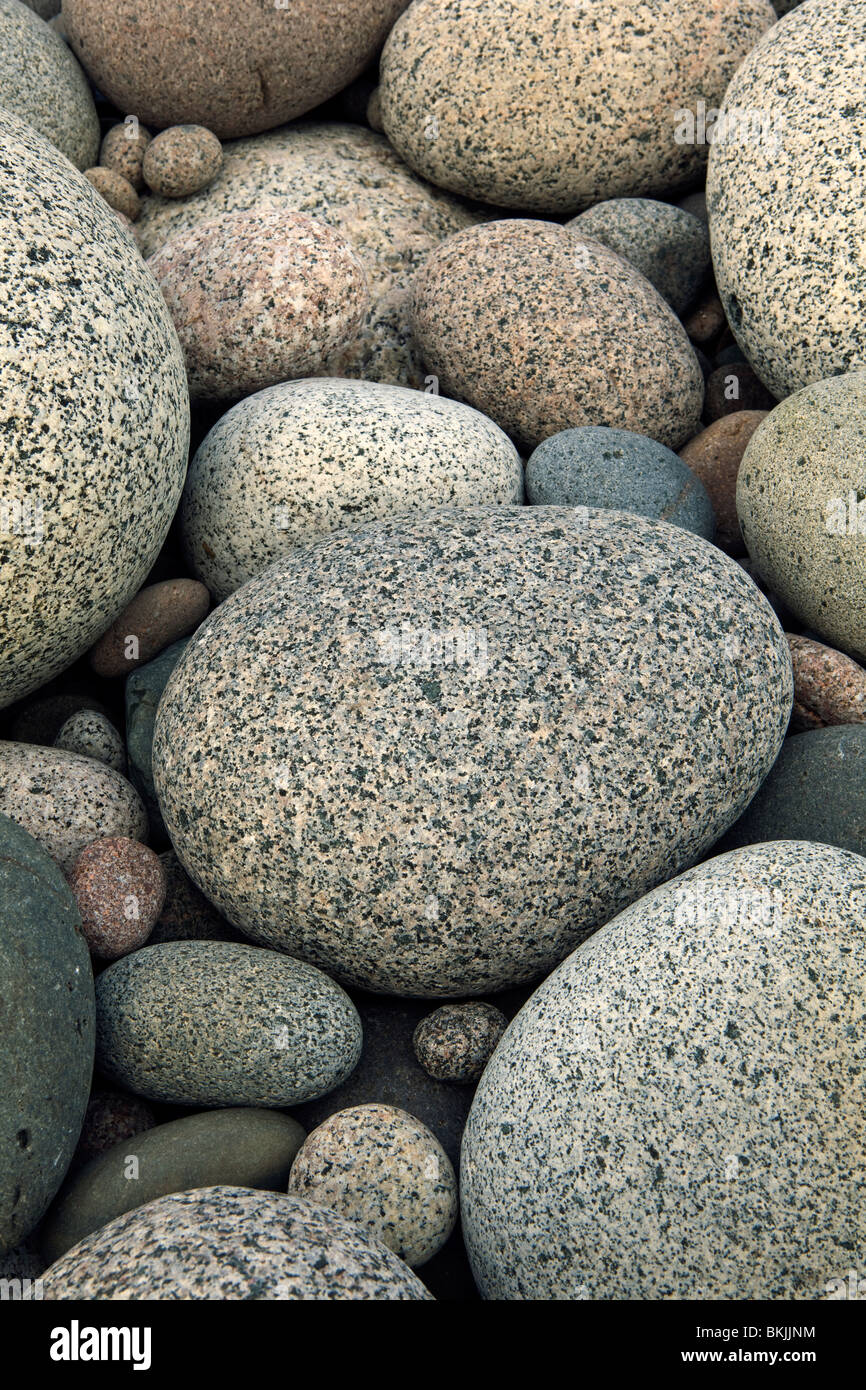 Una fotografia della rotonda liscia di rocce di granito su una spiaggia Foto Stock