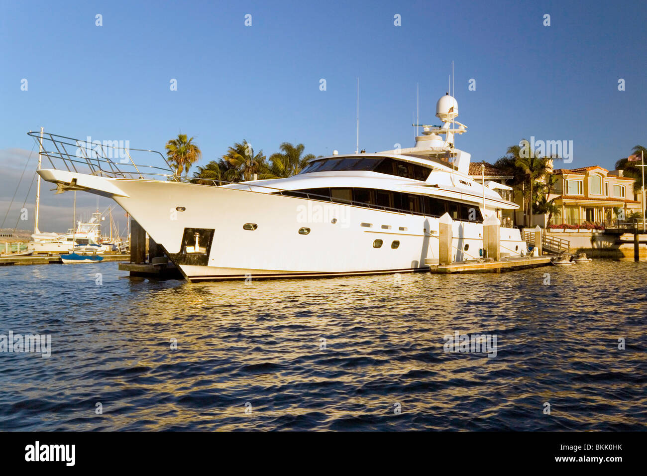 Grande e lussuoso yacht e voglia di svariati milioni di dollari di case sono luoghi di uso quotidiano in Newport Harbor a Newport Beach in California del Sud, Stati Uniti d'America. Foto Stock