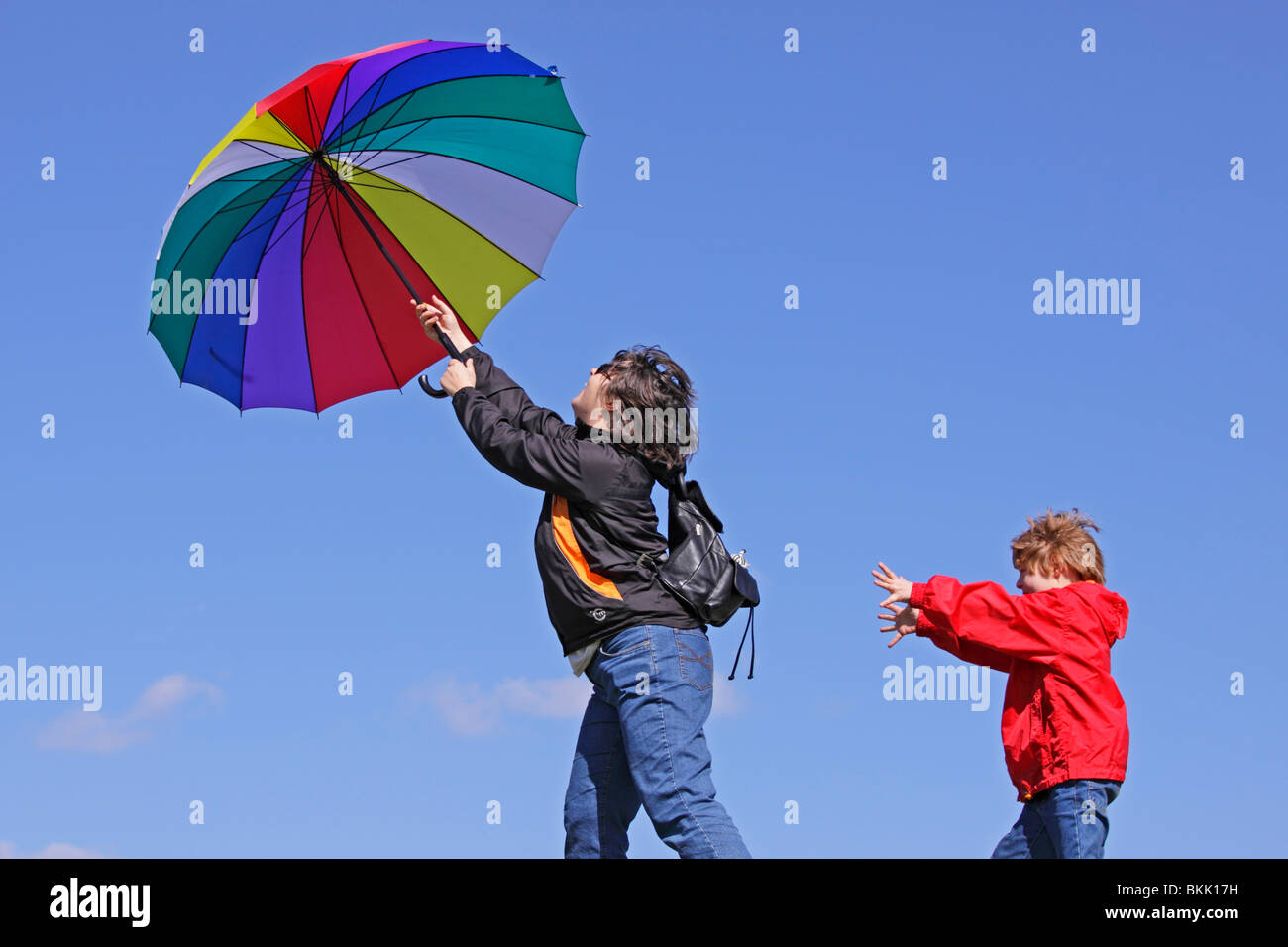 Ragazzo cerca di catturare la sua madre che viene soffiata via dal vento Foto Stock