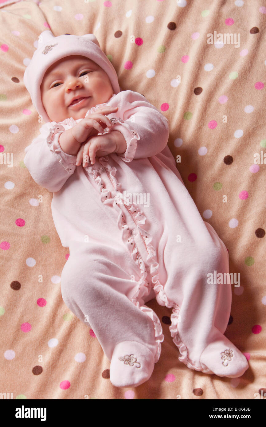 Un neonato bambina indossa un sonno di fronzoli e un cappuccio Foto Stock