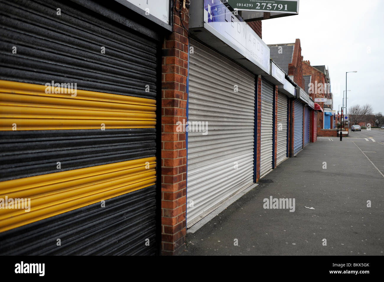 Negozi e proprietà chiusa con serrande metalliche in giù a Hartlepool town centre REGNO UNITO Foto Stock