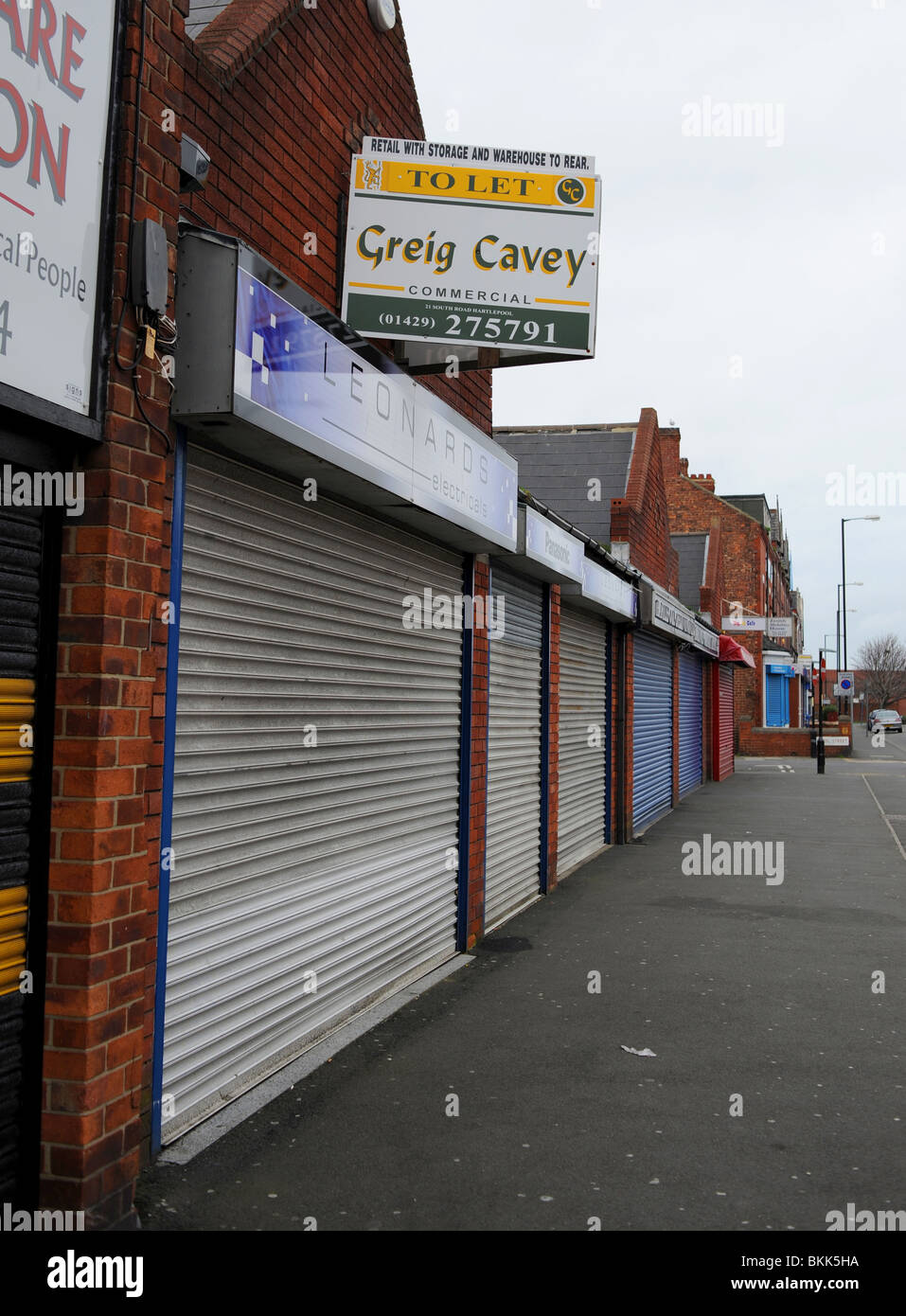 Negozi e proprietà chiusa con serrande metalliche in giù a Hartlepool town centre REGNO UNITO Foto Stock