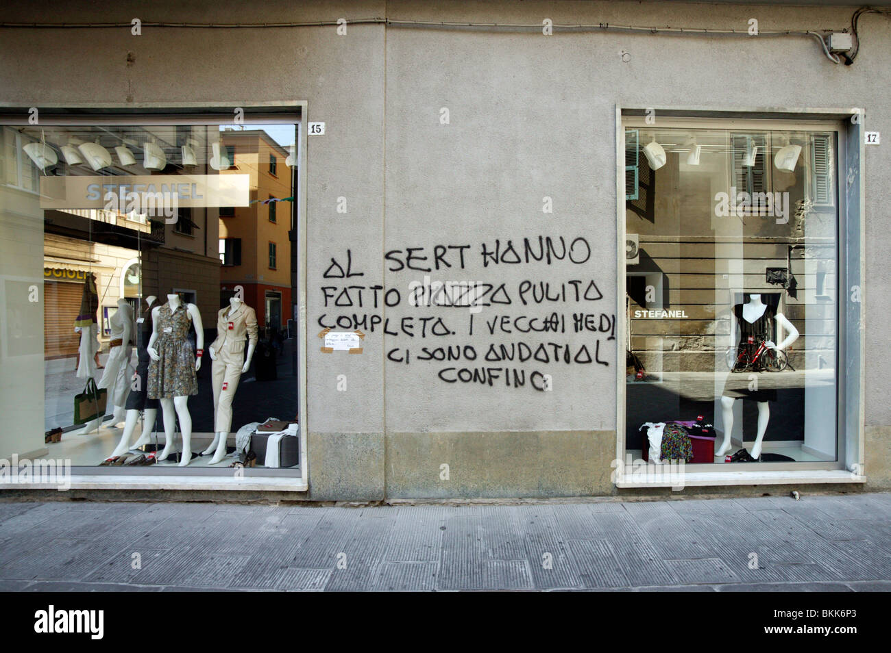 La scrittura su pareti da un negozio di abbigliamento finestra, Genova,  Italia Foto stock - Alamy
