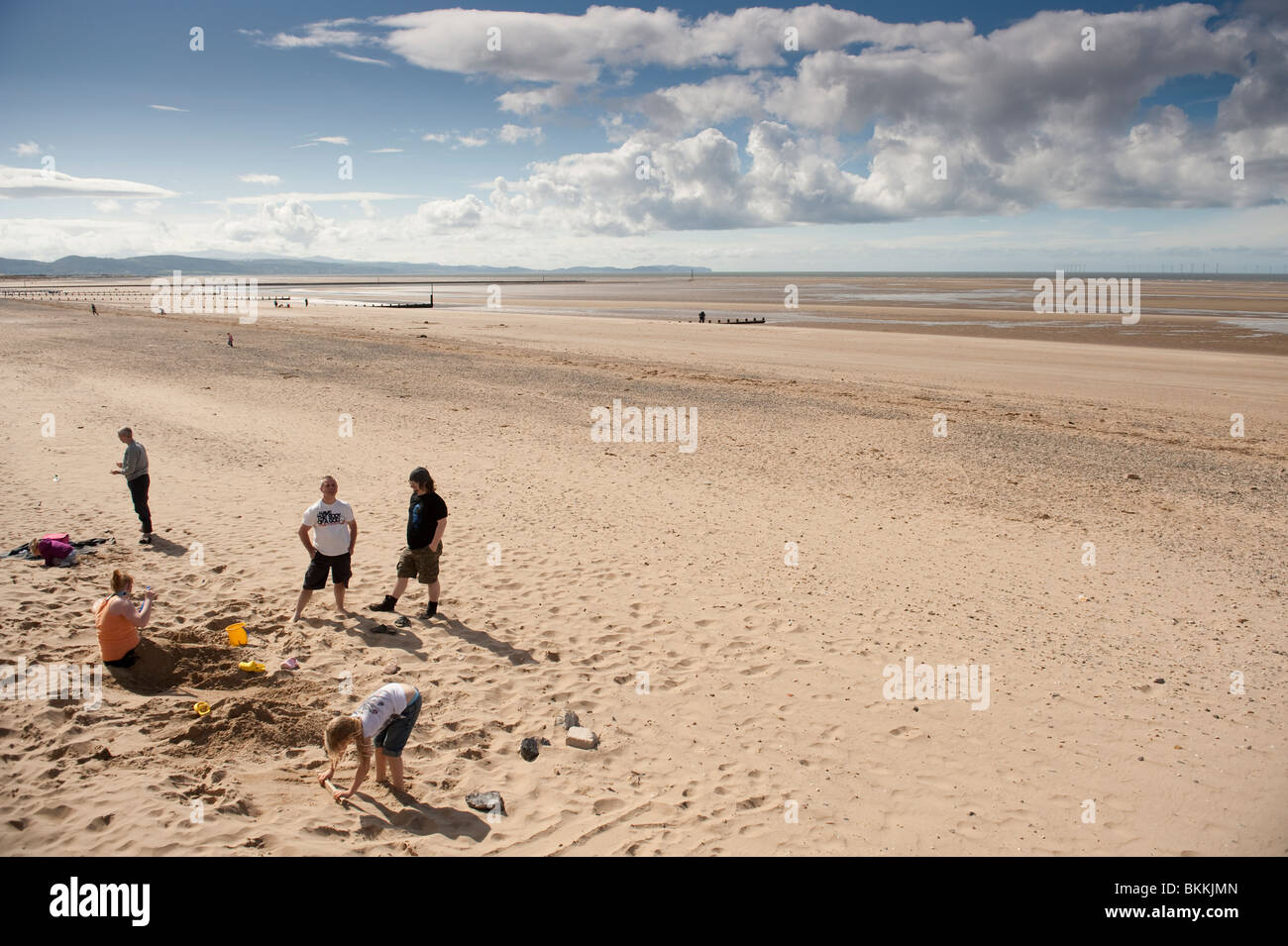 Una famiglia sulla spiaggia deserta e mare, Rhyl, north Wales UK Foto Stock