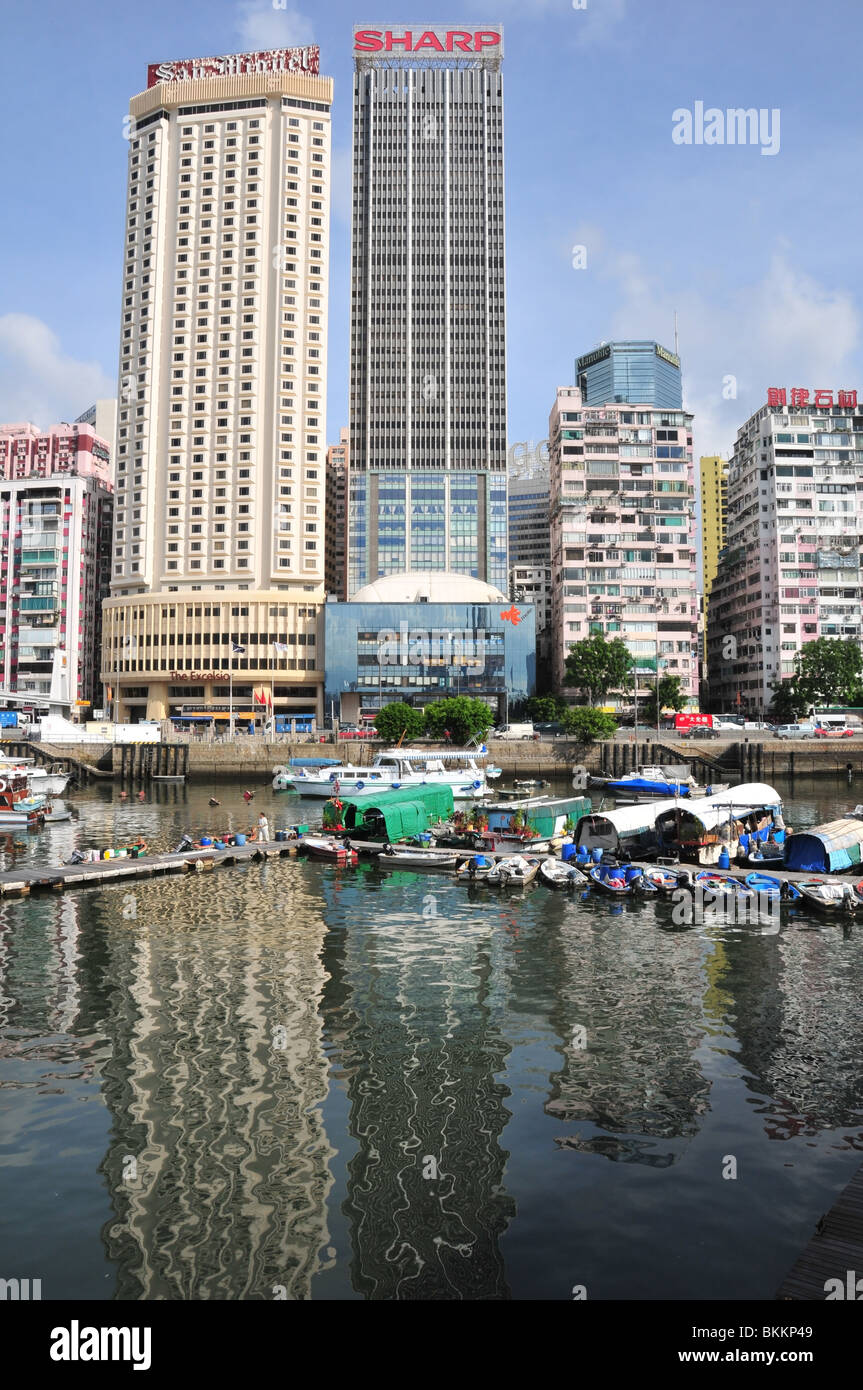 Case galleggianti ormeggiate nei riflessi del Hotel Excelsior e il World Trade Center, Causeway Bay Typhoon Shelter, Hong Kong Foto Stock