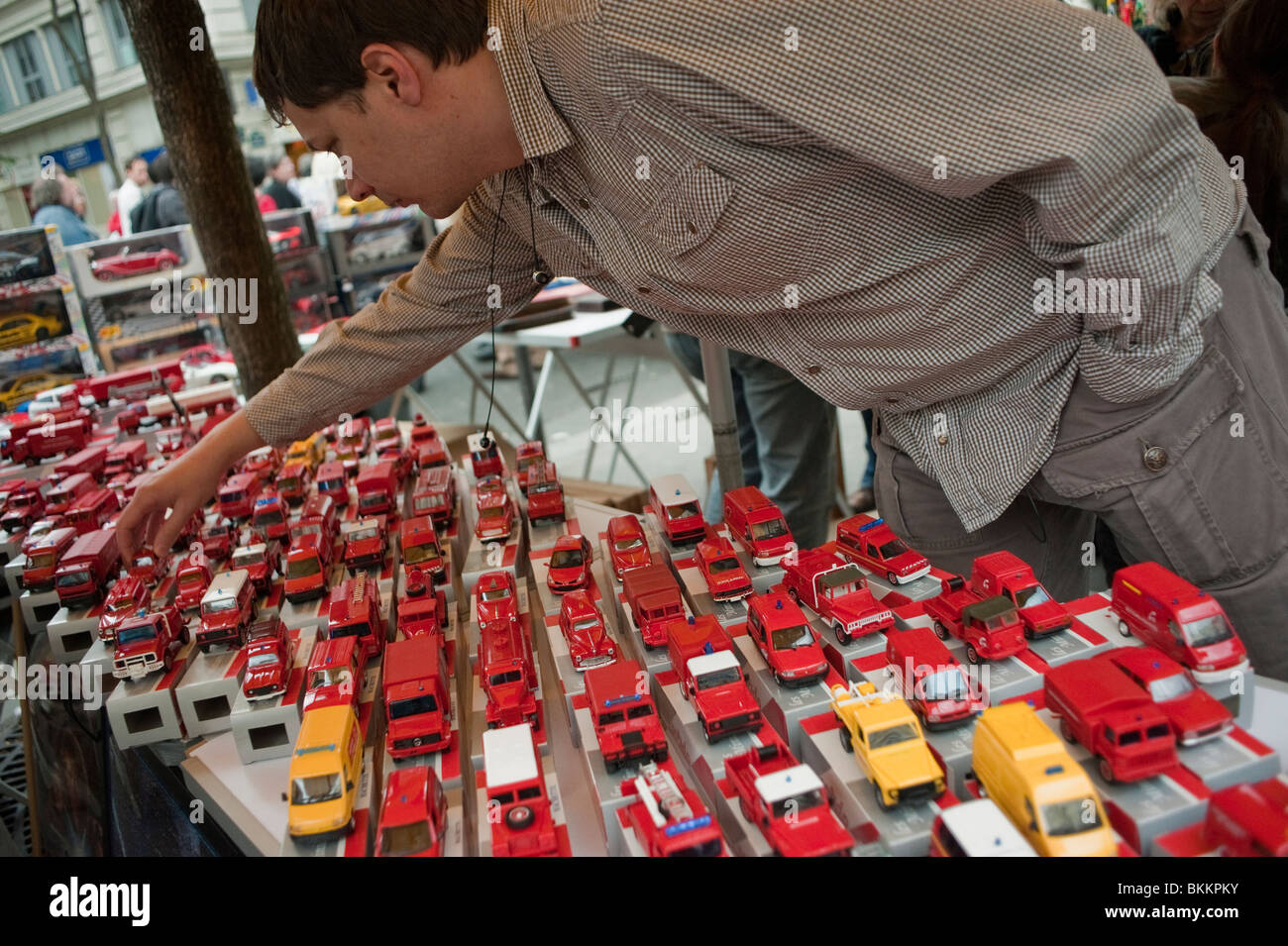 L'uomo Shopping per " Seconda Mano' giocattolo per bambini è auto sulla strada di vendita di garage, Parigi, Francia, Vintage Toys Foto Stock