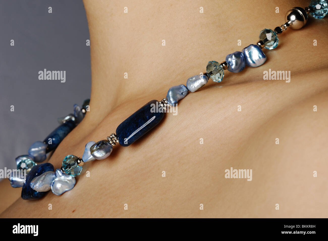 La pietra blu, perla, la shell e la collana di cristallo gioielli sul collo assottigliata. Foto Stock