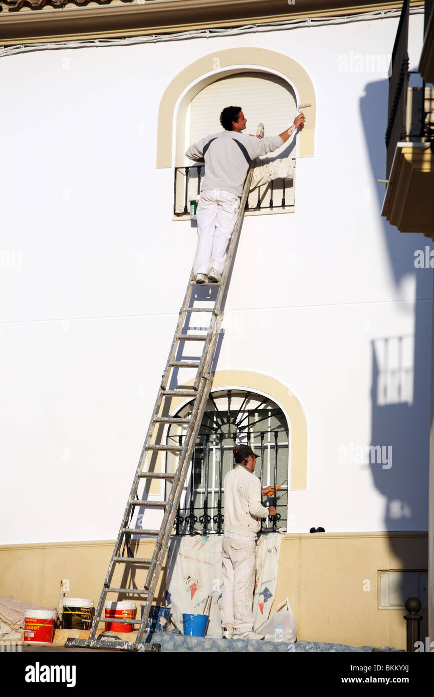 Due uomini verniciatura di una casa nella città andalusa di Almodovar Del Rio, Spagna, Europa Foto Stock