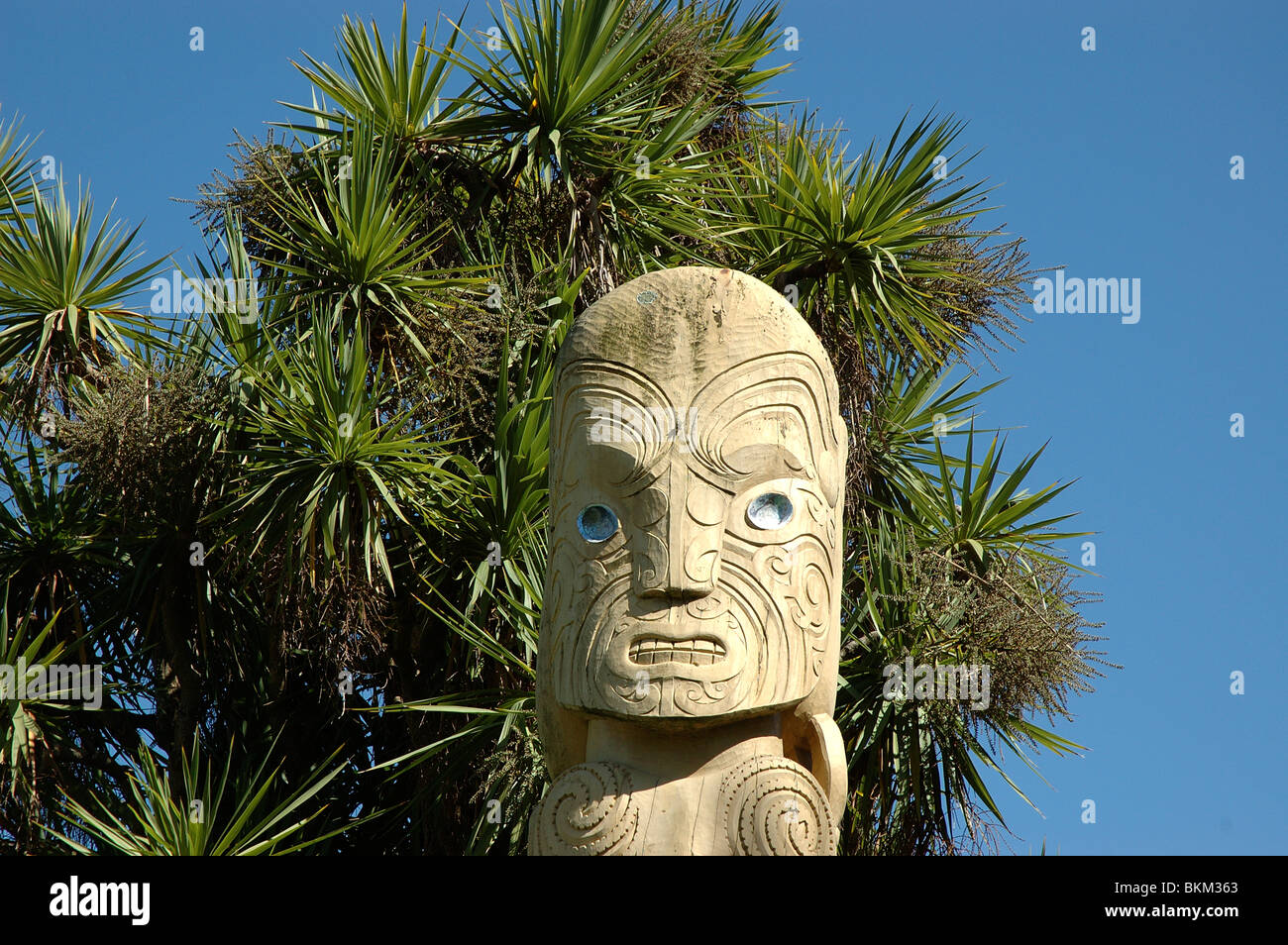 In legno scolpito a capo di un post Maori accanto al fiume Avon a Christchurch, Nuova Zelanda Foto Stock