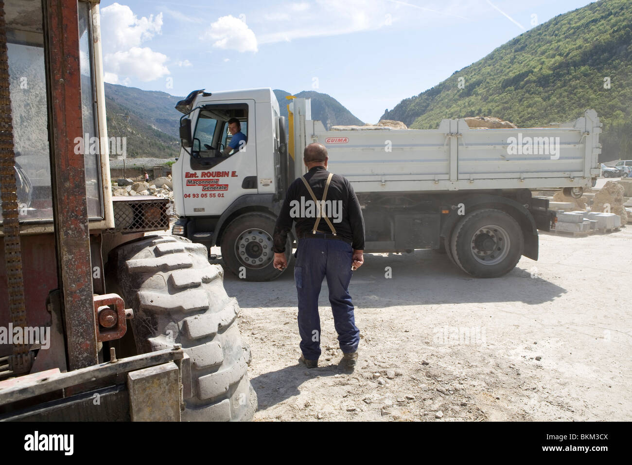 Pierre, uno scalpellatore, riceve una consegna di pietra in un camion alla cava di Entrevaux, sulle Alpi francesi Foto Stock