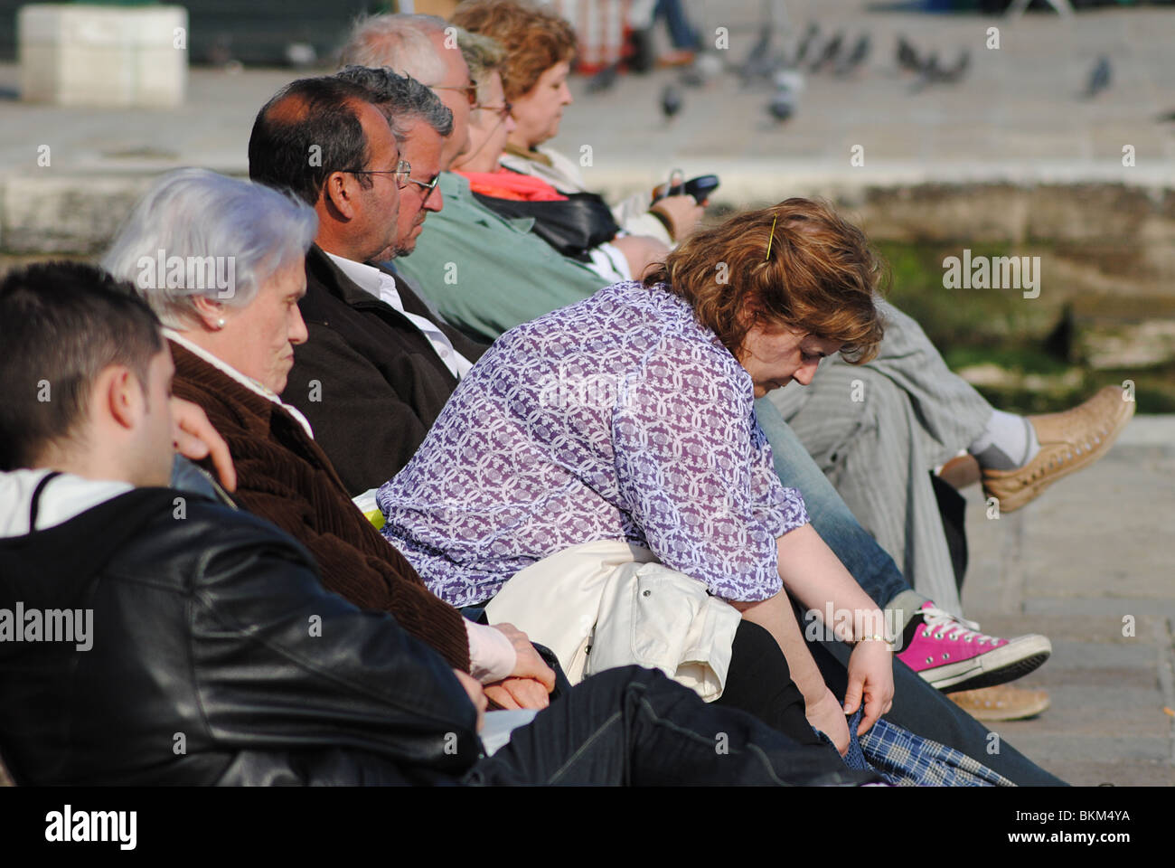 Anziani italiani a sedersi su una panchina a Venezia, Italia Foto Stock