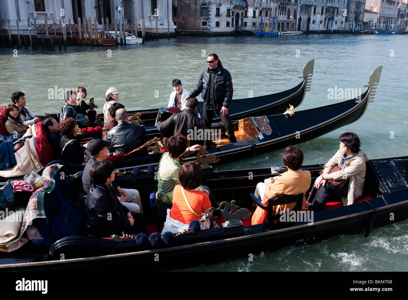 Gondoliere cantando arie d'opera per i turisti giapponesi in gondole sul Grand Vanal in Italia Foto Stock
