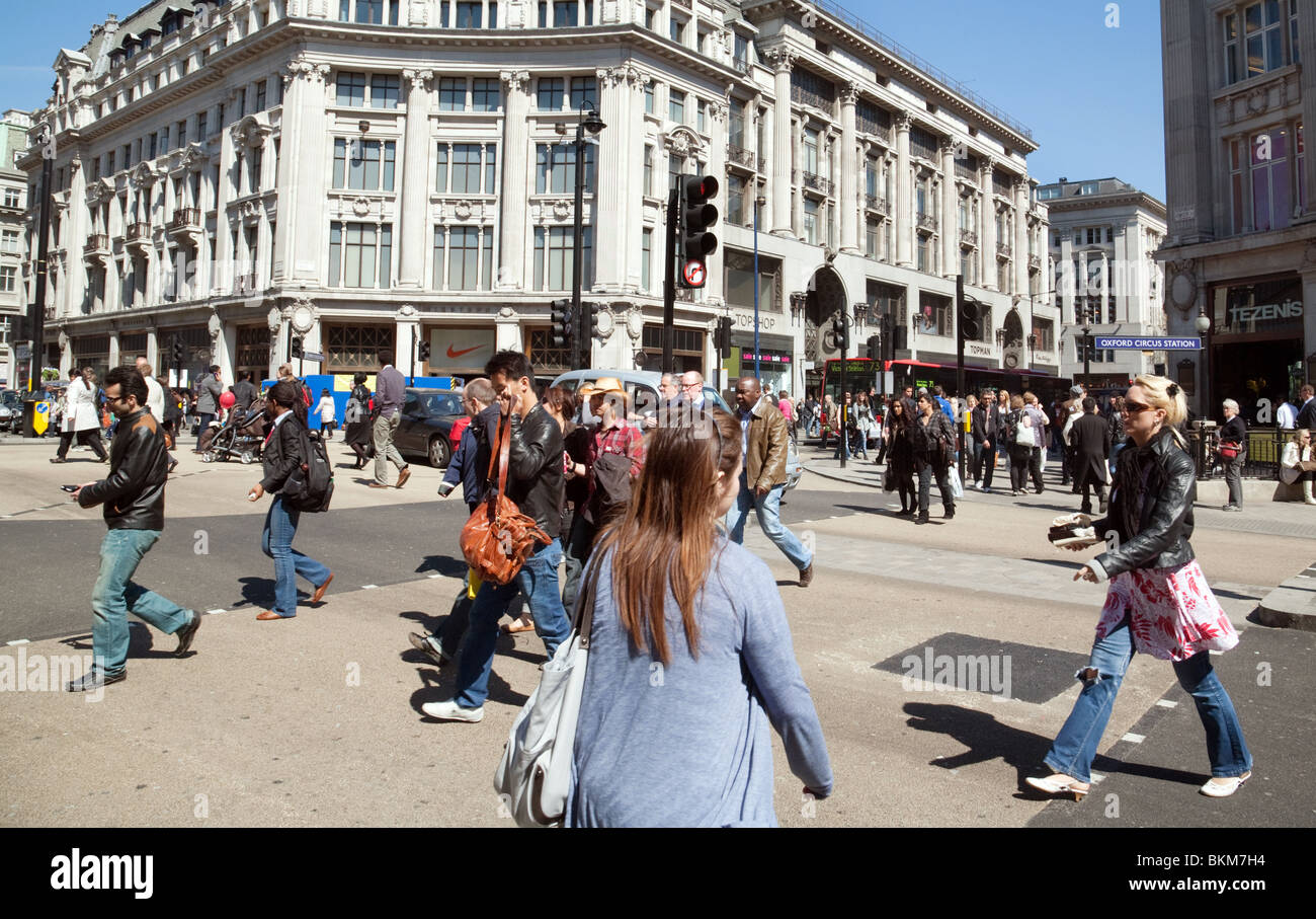 Una folla di persone che attraversano la strada a Oxford Circus, London REGNO UNITO Foto Stock