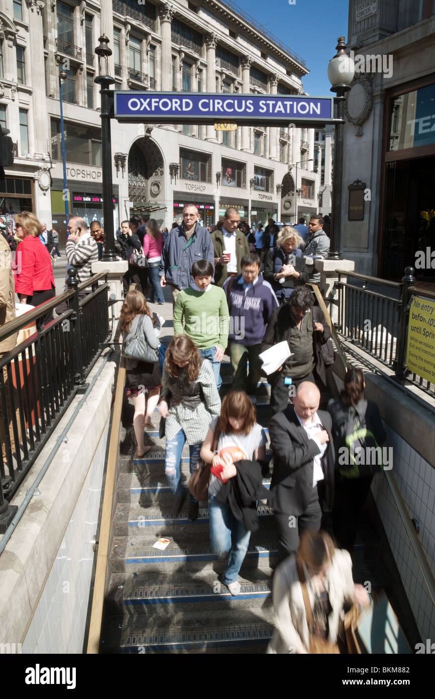 Persone di andare giù per la stazione della metropolitana (metropolitana), Oxford Circus, London REGNO UNITO Foto Stock