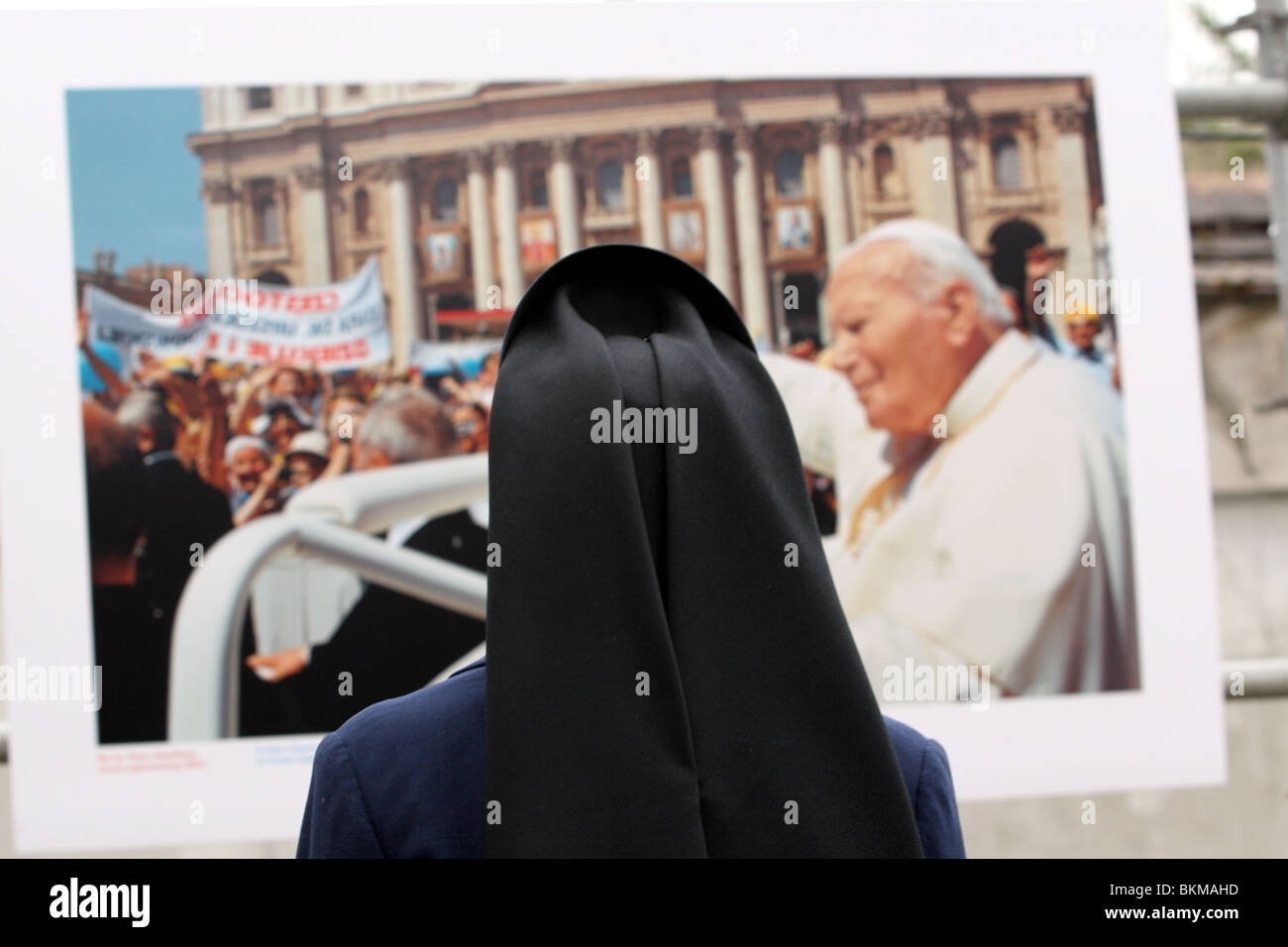 Nun guardando una foto del compianto Papa Giovanni Paolo 2a Cracovia Polonia Foto Stock